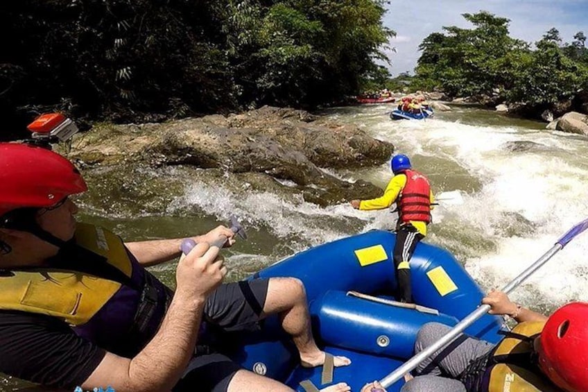A river rafting activity with participants in blue and yellow rafts navigating through rapids. 1
