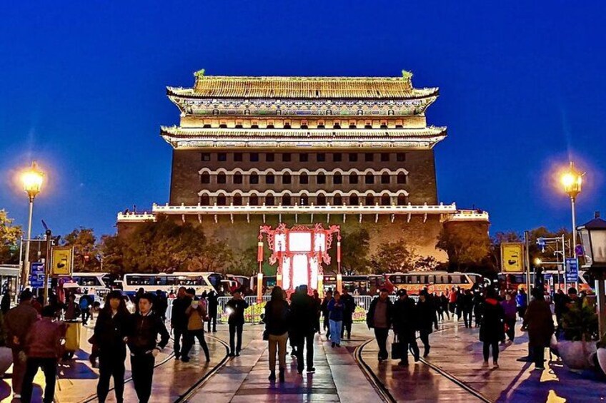 A traditional Chinese gate with ornate decorations and a crowd of people in front. 2