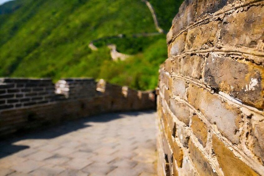 A section of the Great Wall of China with stone bricks and a mountainous background. 5
