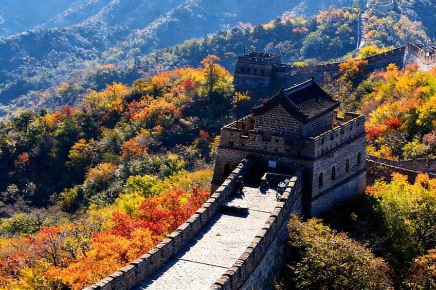 The Great Wall of China with autumn foliage, a watchtower, and mountainous terrain. 4