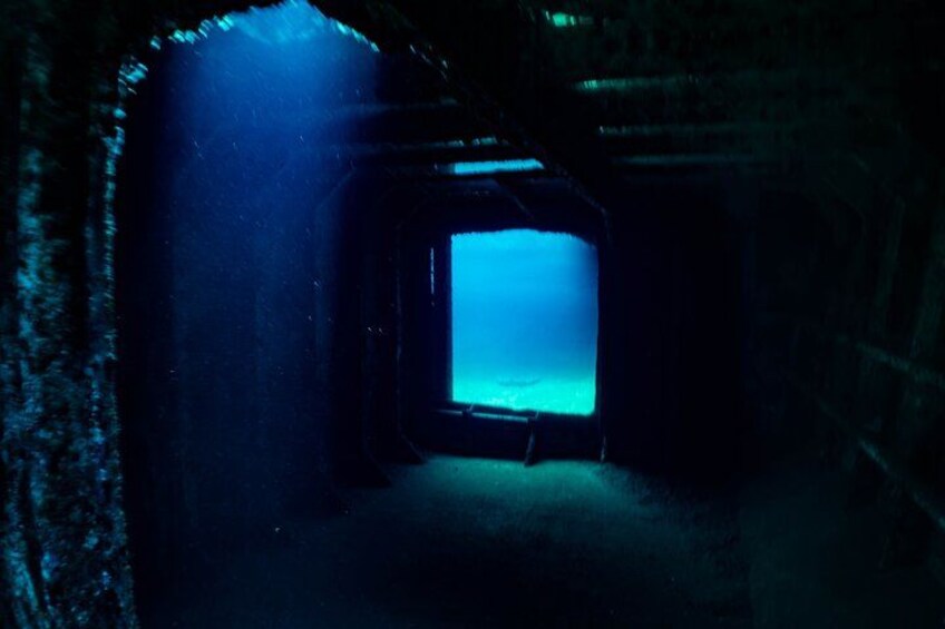 A dark tunnel with a blue light at the end. 5