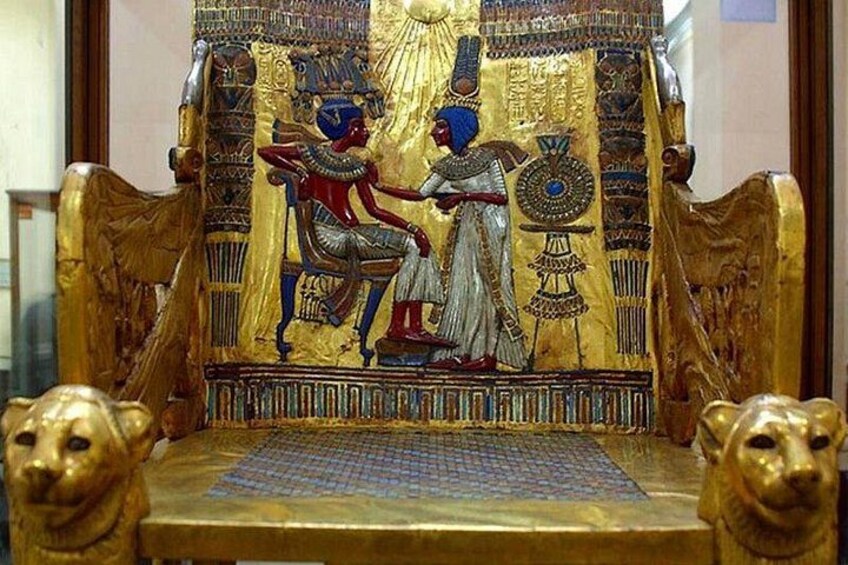 En gylden trone med detaljerede hieroglyffer og en siddende figur. 4