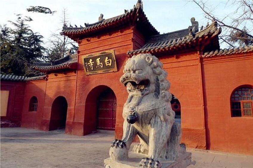 A traditional Chinese building with a lion statue in front. 4