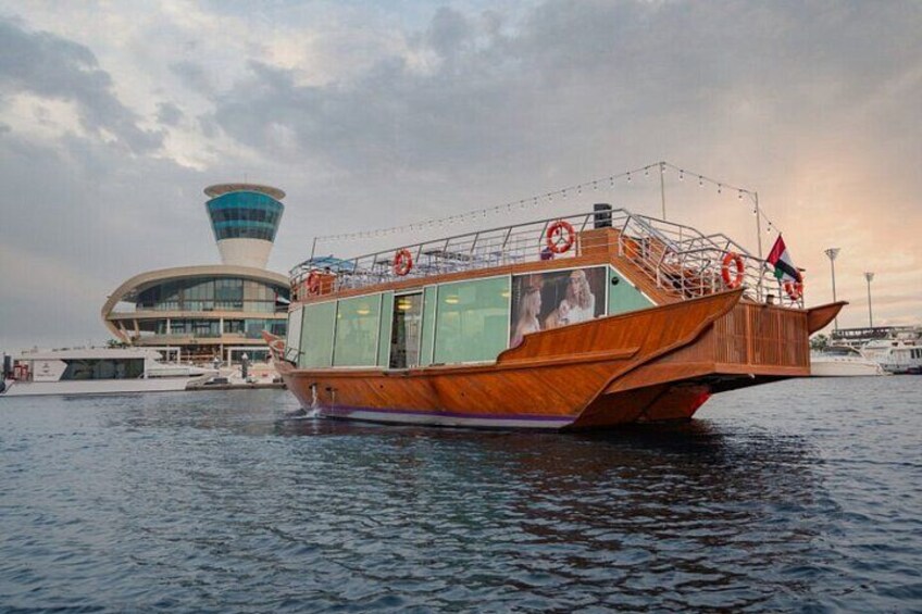 A wooden boat with lifebuoys, a control tower, and a flag in the background. 4
