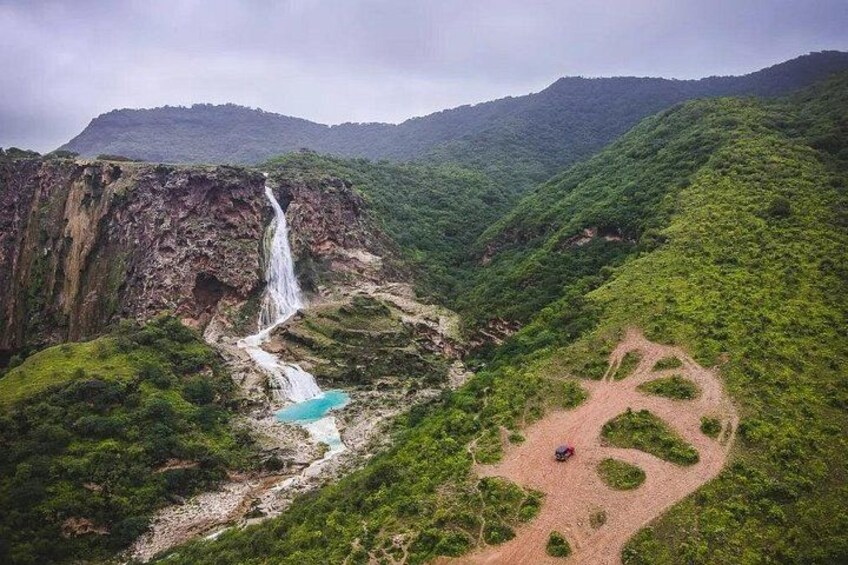 A waterfall, a river, and a hiking trail in a mountainous area. 3