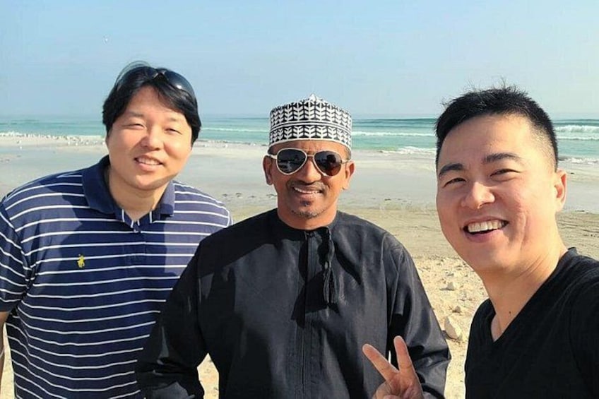 Three people on a beach with ocean in the background. 5