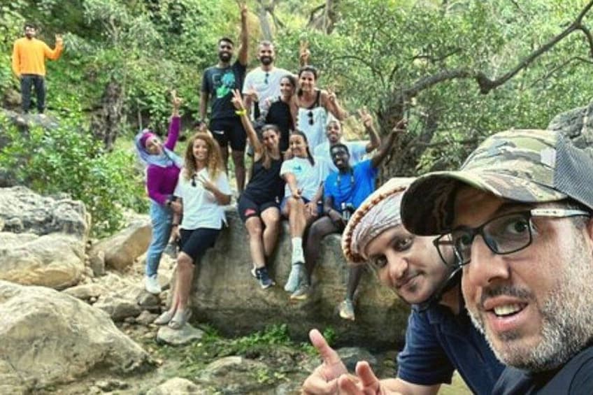 A group of people sitting on rocks in a forested area. 3