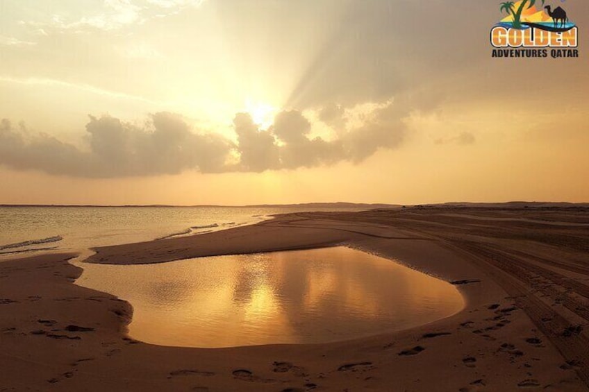 A desert landscape with a body of water reflecting the sun. 4
