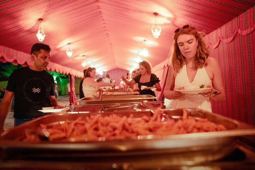 Een tent waar eten wordt geserveerd, met personeel. 2