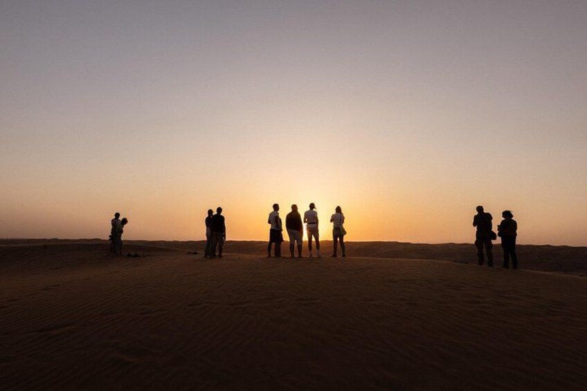 Un grupo de personas en un paisaje desértico durante el atardecer. 5
