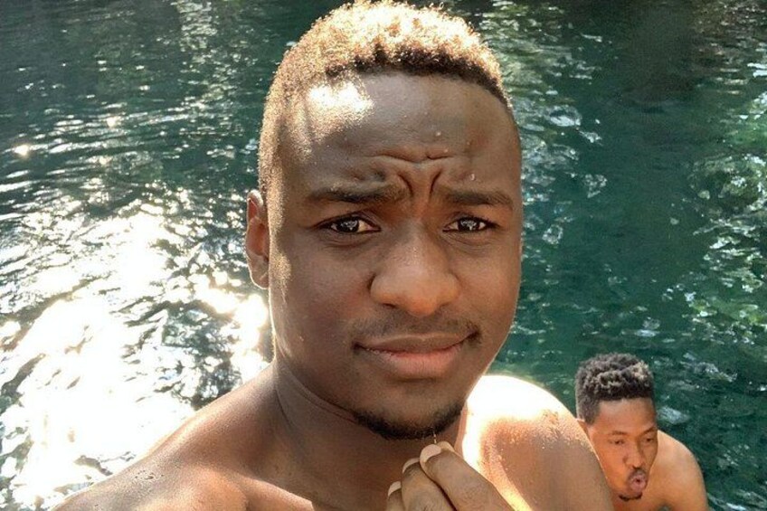 Una persona en una piscina con agua cristalina y reflejos de sol en la superficie. 3