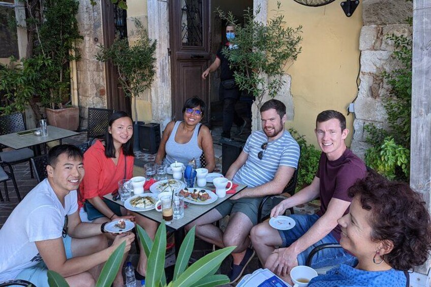 Un gruppo di persone sedute a un tavolo all'aperto, con cibo e bevande. 3