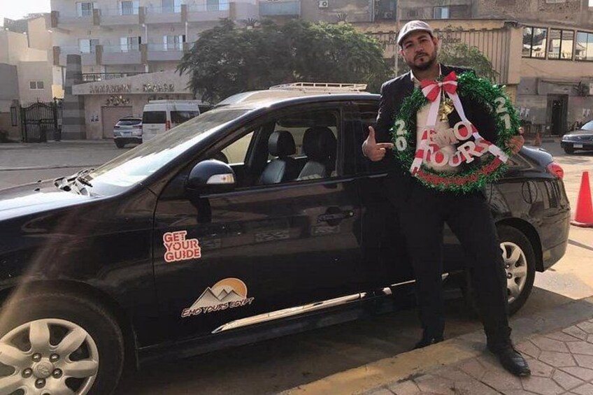 Un'auto nera con un adesivo con su scritto 'GET YOUR GUIDE' e una ghirlanda con la scritta 'Merry Love'. 2
