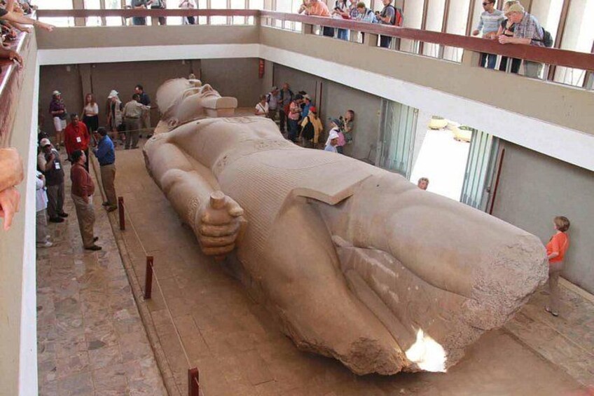 A large sarcophagus with a figure lying inside, surrounded by visitors. 2
