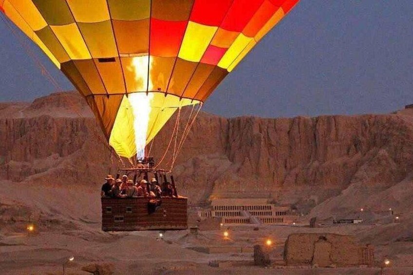 Un globo aerostático con pasajeros sobre un paisaje desértico. 4