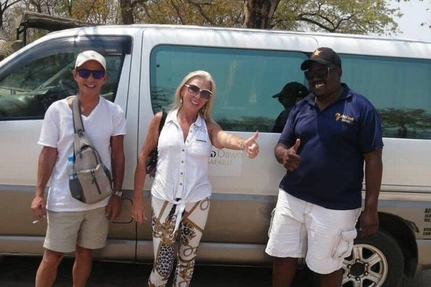 Three people standing in front of a van with a logo on the side. 5