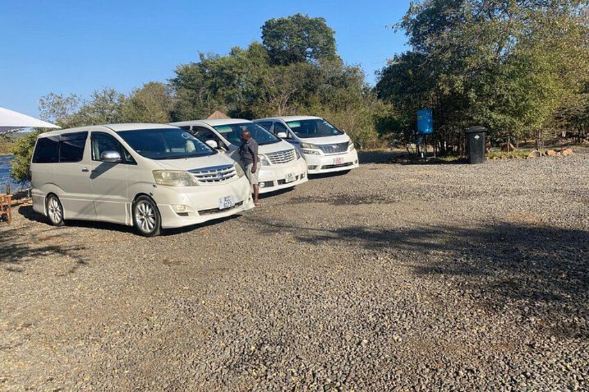 A gravel parking area with three white vans parked. 2