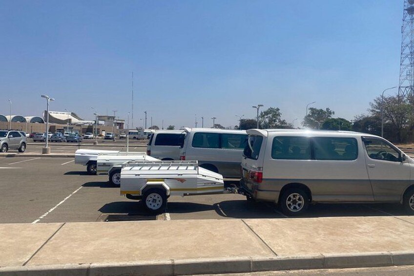 A parking lot with several vehicles, including vans and a trailer. 4