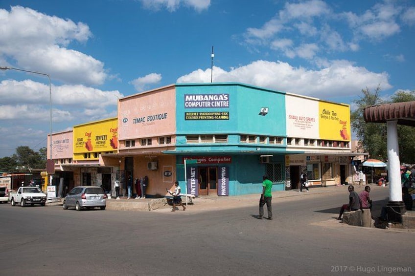 Una calle con un edificio que lleva las etiquetas 'Mubanga's Computer Centre' y 'Temac Boutique'. 1