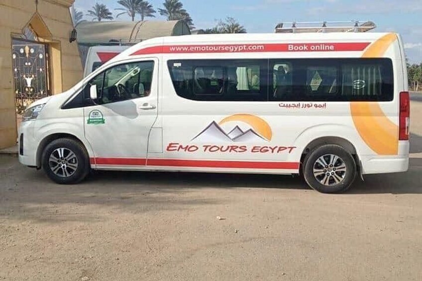 Een witte bus met 'EMO TOURS EGYPT' en 'www.emotoursegypt.com' op de zijkant. 3