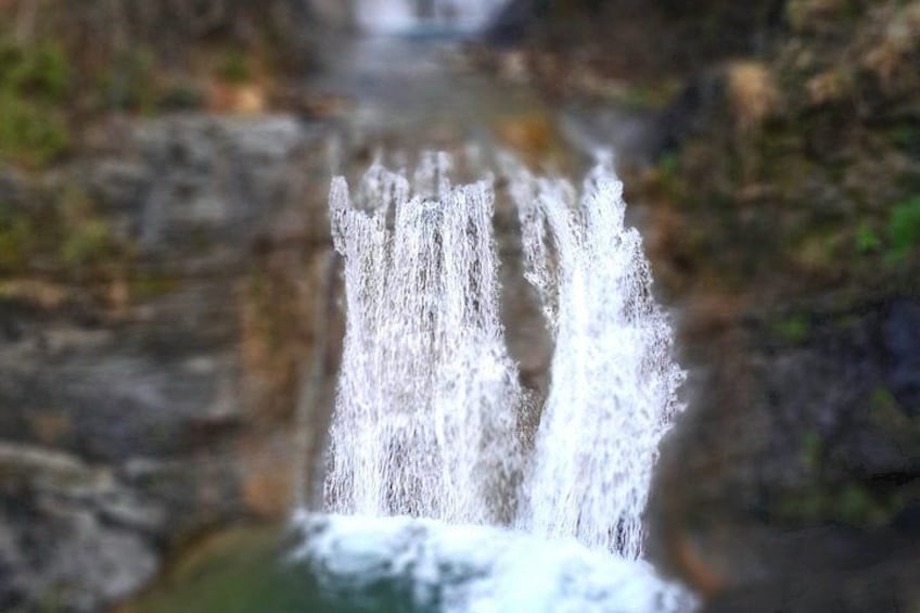 A waterfall with water cascading down a rocky surface. 3