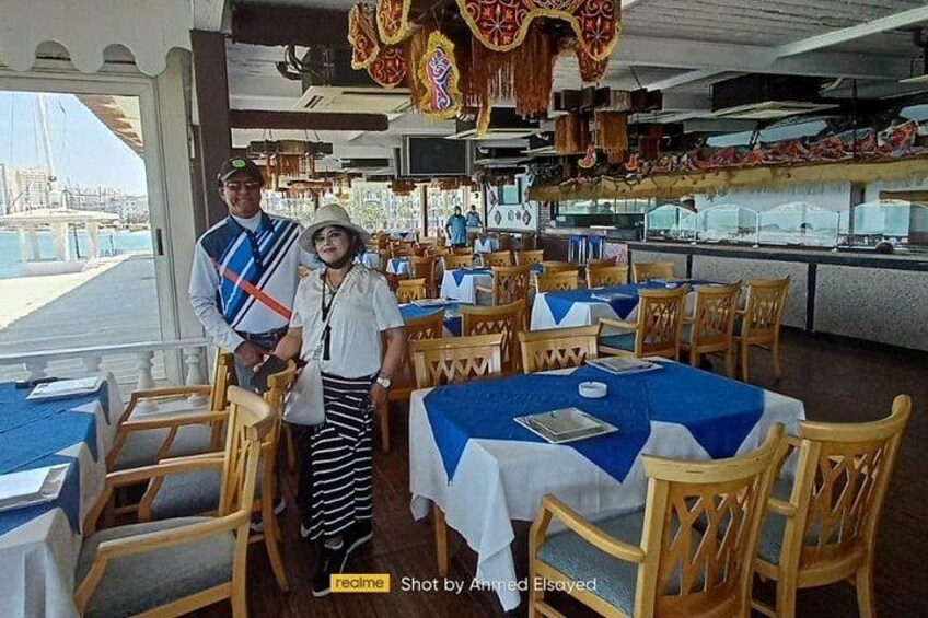 Un restaurante con mesas cubiertas de manteles azules, sillas de madera y vistas al mar. 4
