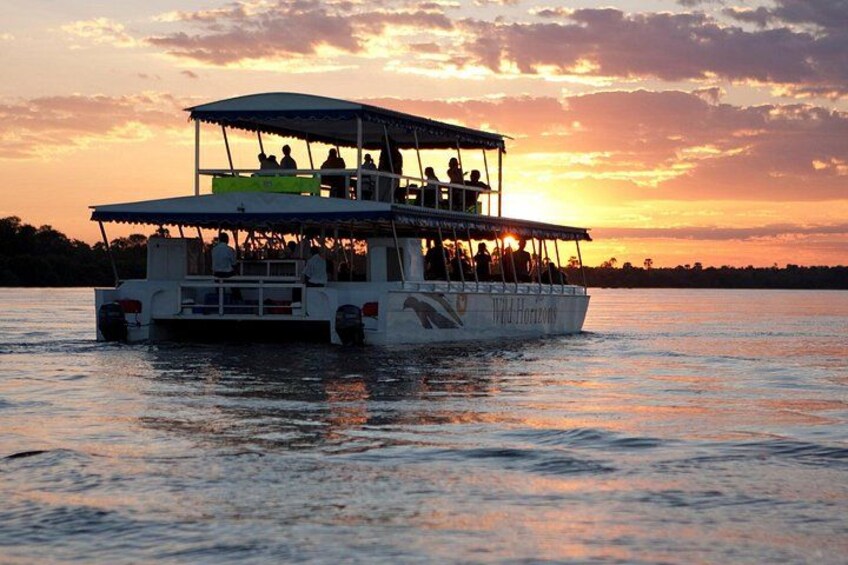 Un bote con personas navegando sobre el agua durante el atardecer. 1