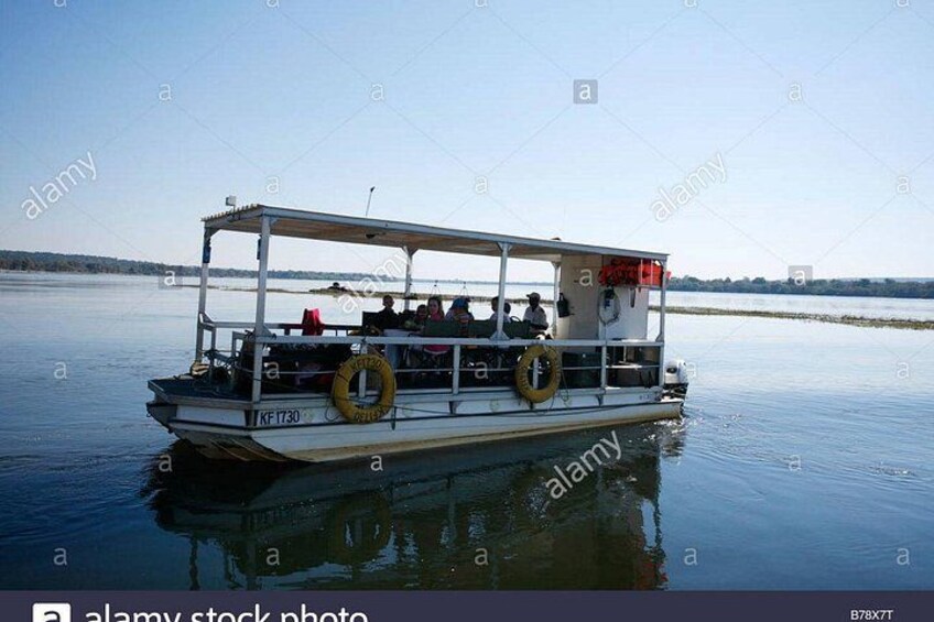 Un bote con pasajeros, boyas salvavidas y un cielo despejado. 5