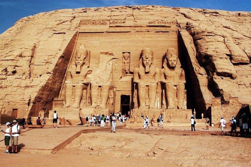 A large rock-cut temple with multiple statues and hieroglyphics. 1