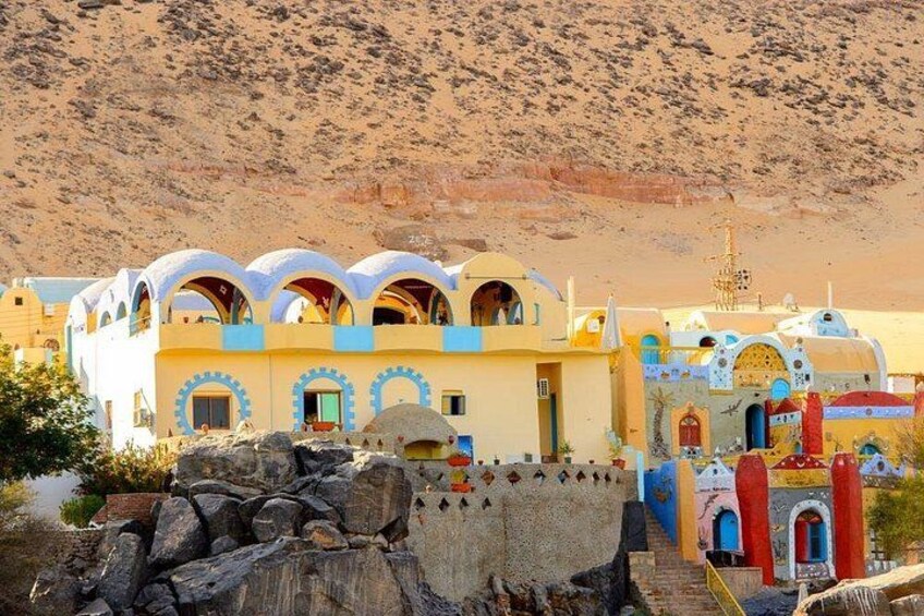 Un edificio colorido con múltiples arcos y cúpulas, frente a un paisaje desértico. 2