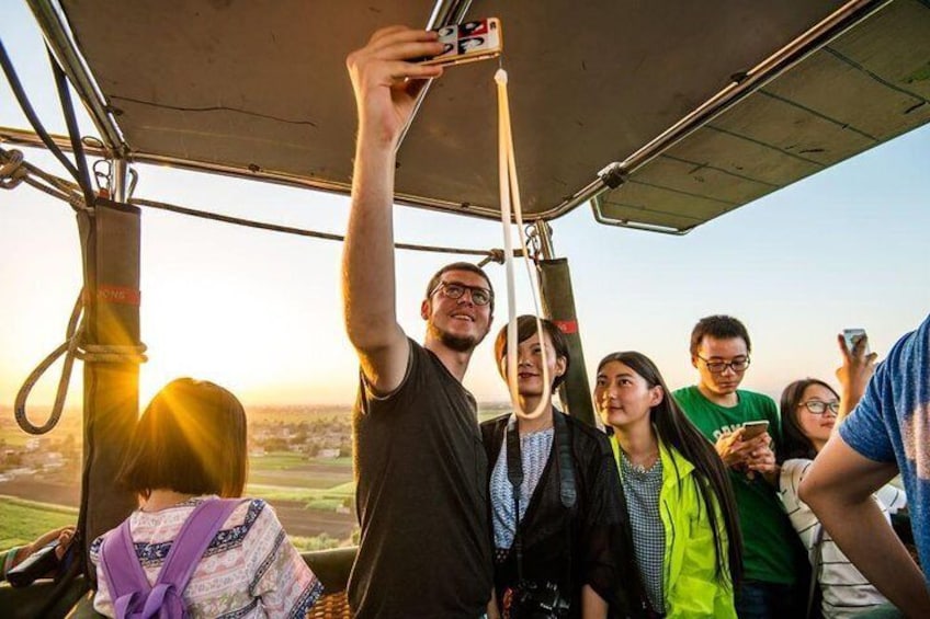 Een groep mensen tijdens een helikoptertour, die een smartphone omhoog houden om een foto te maken. 5