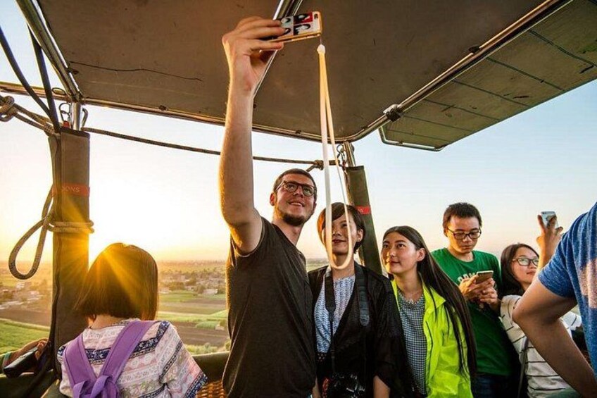 A group of people inside a vehicle, possibly a helicopter, with a landscape visible through the window. 3
