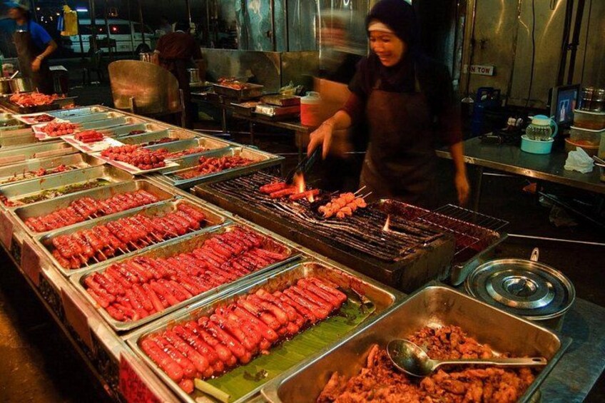 Een kraam met diverse gegrilde vleessoorten en sauzen. 1