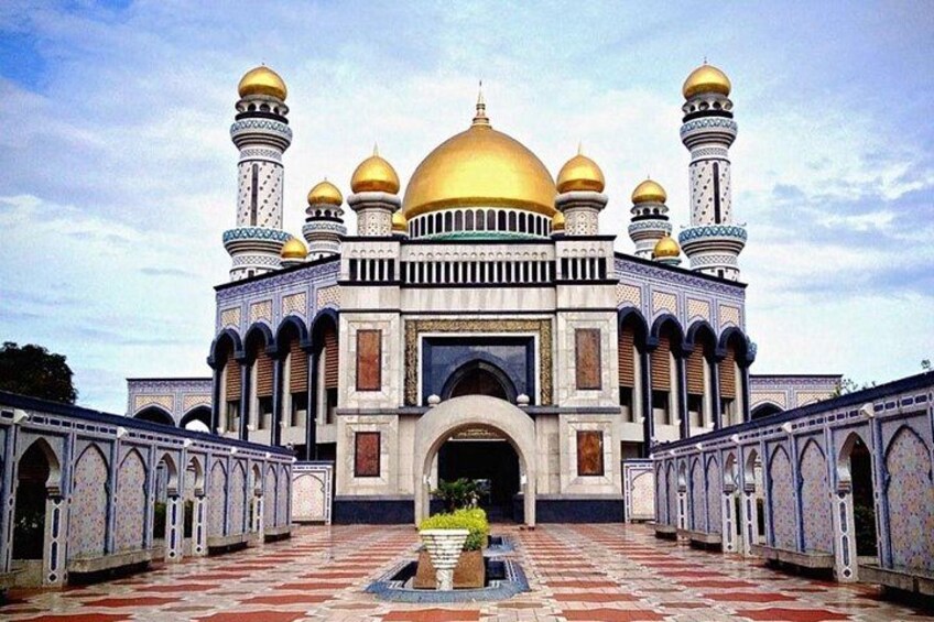 Een grote moskee met meerdere koepels en minaretten, een binnentuin met geometrische tegels en een centrale boog. 5