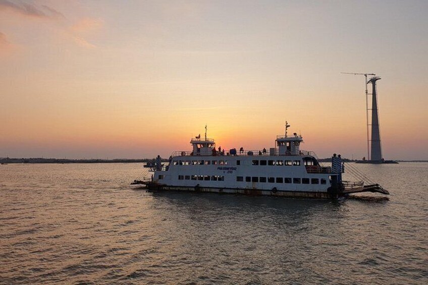 A ferry boat on a body of water during sunset. 3