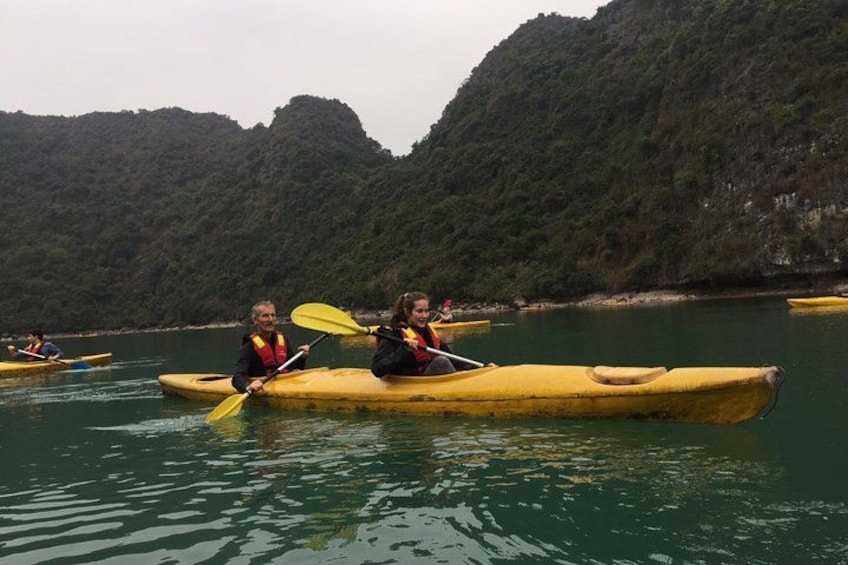 People kayaking on calm water surrounded by green hills. 5