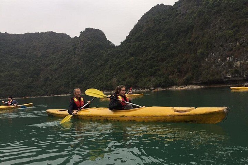 People kayaking on a calm river surrounded by forested hills. 5