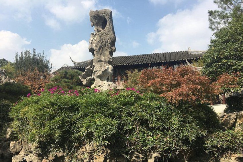 A traditional Chinese building with a distinctive rock formation in front. 2