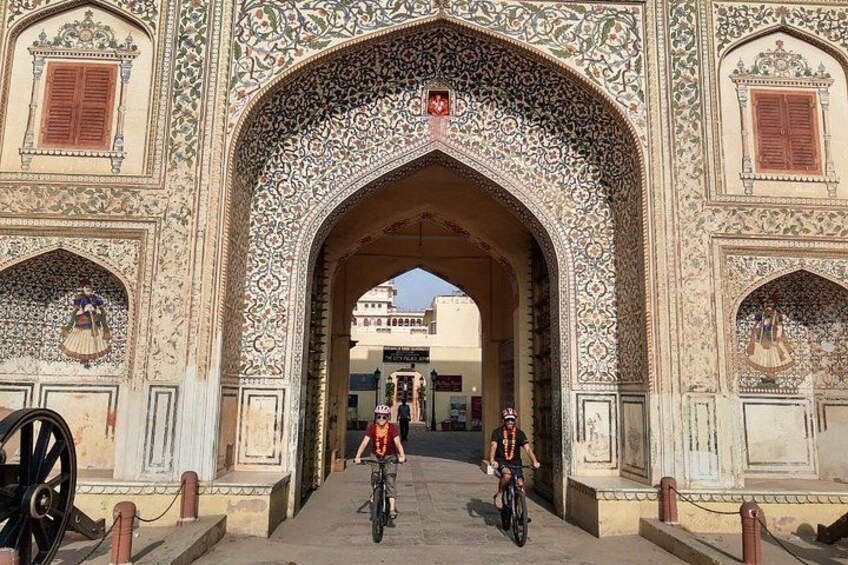 An ornate archway with intricate designs, a bicycle, and a person riding a bicycle. 3