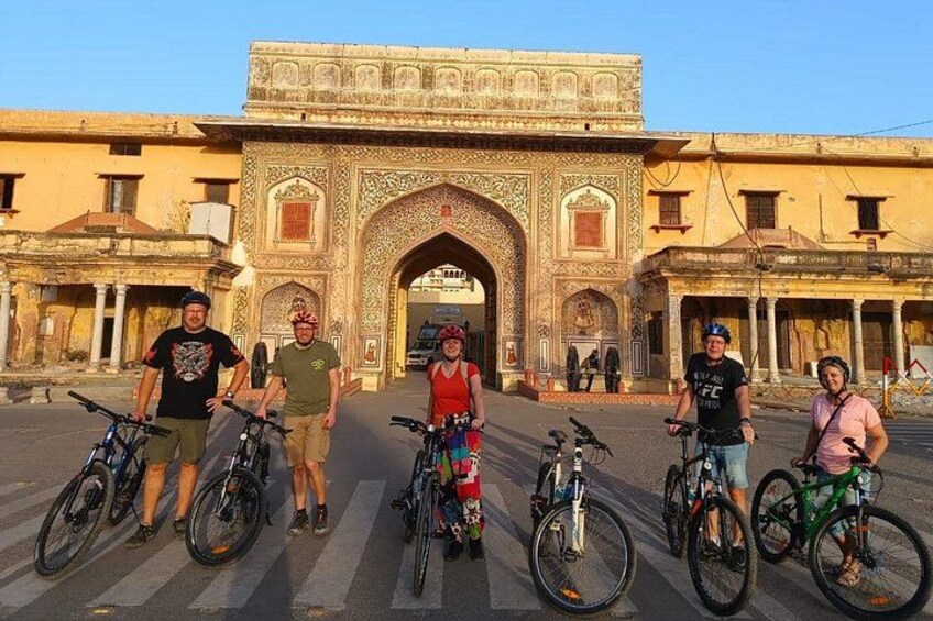 A group of people with bicycles in front of an ornate historical building. 5