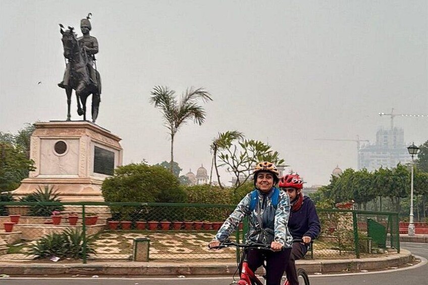 A statue of a mounted figure, a cyclist wearing a helmet, and a person in a wheelchair. 2