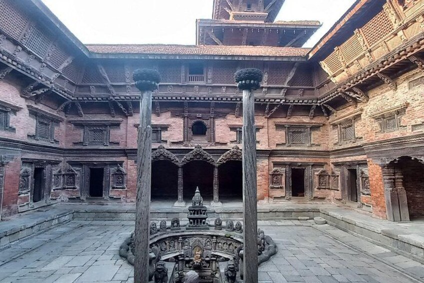 A courtyard with a central fountain, surrounded by traditional brick architecture with intricate carvings. 2