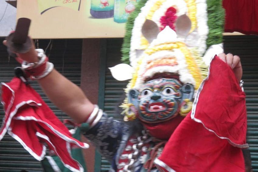 A person in a red and white costume with a mask, holding a red cloth. 5