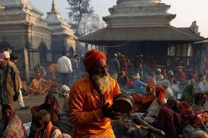 A crowded outdoor religious site with people gathered around a central figure in traditional attire. 4