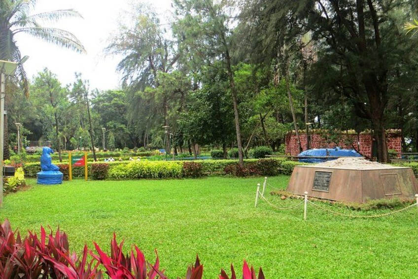 A well-maintained park with a grassy area, a blue sculpture, and a brick structure. 3