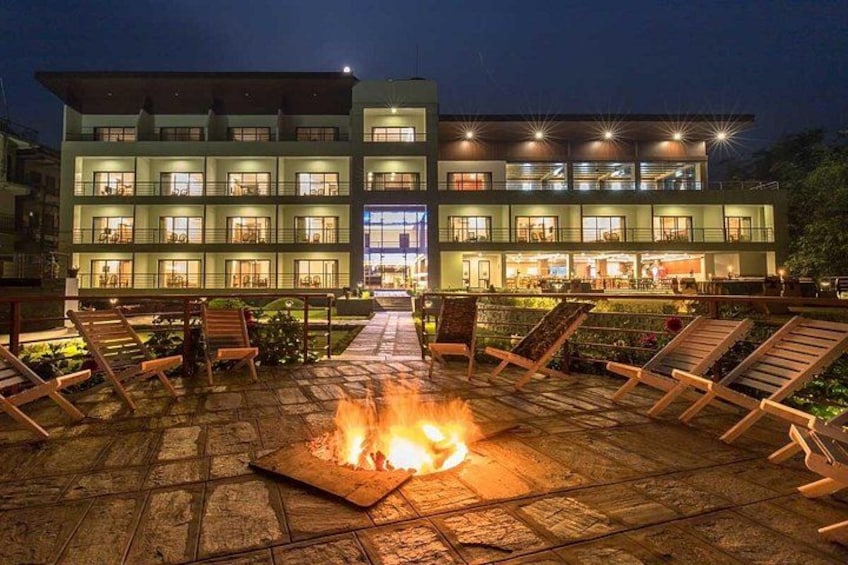 A building with multiple floors, outdoor seating, and a fire pit. 5