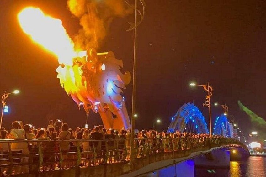 A bridge with a dragon-like structure with flames, illuminated by blue lights. 1