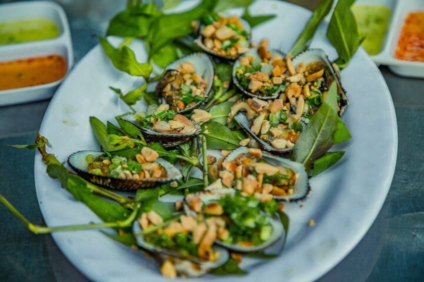 A plate of food with shellfish and greens. 4