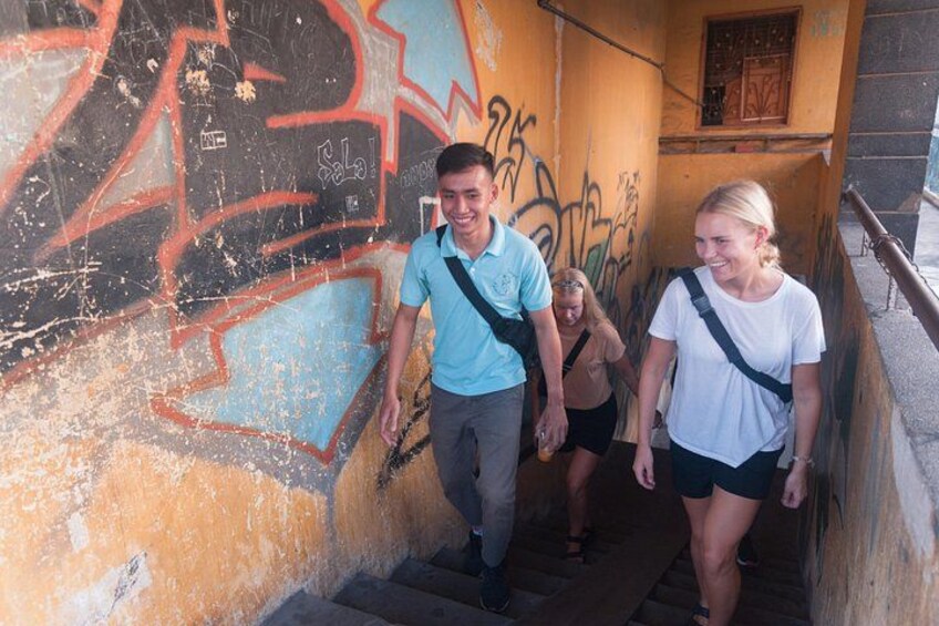 A group of people walking on a staircase with graffiti on the wall. 3