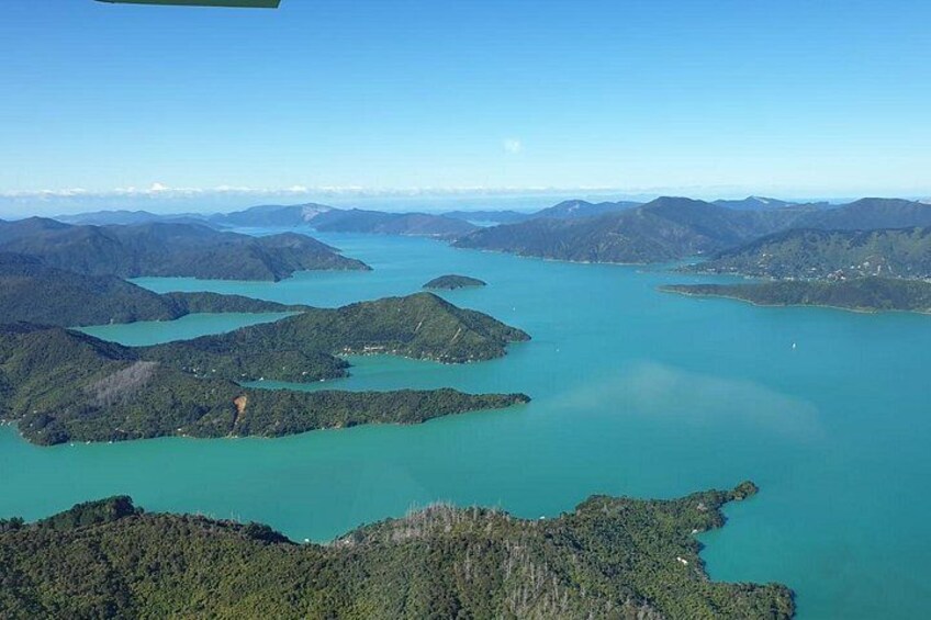 A coastal landscape with multiple islands surrounded by turquoise waters and green hills. 3